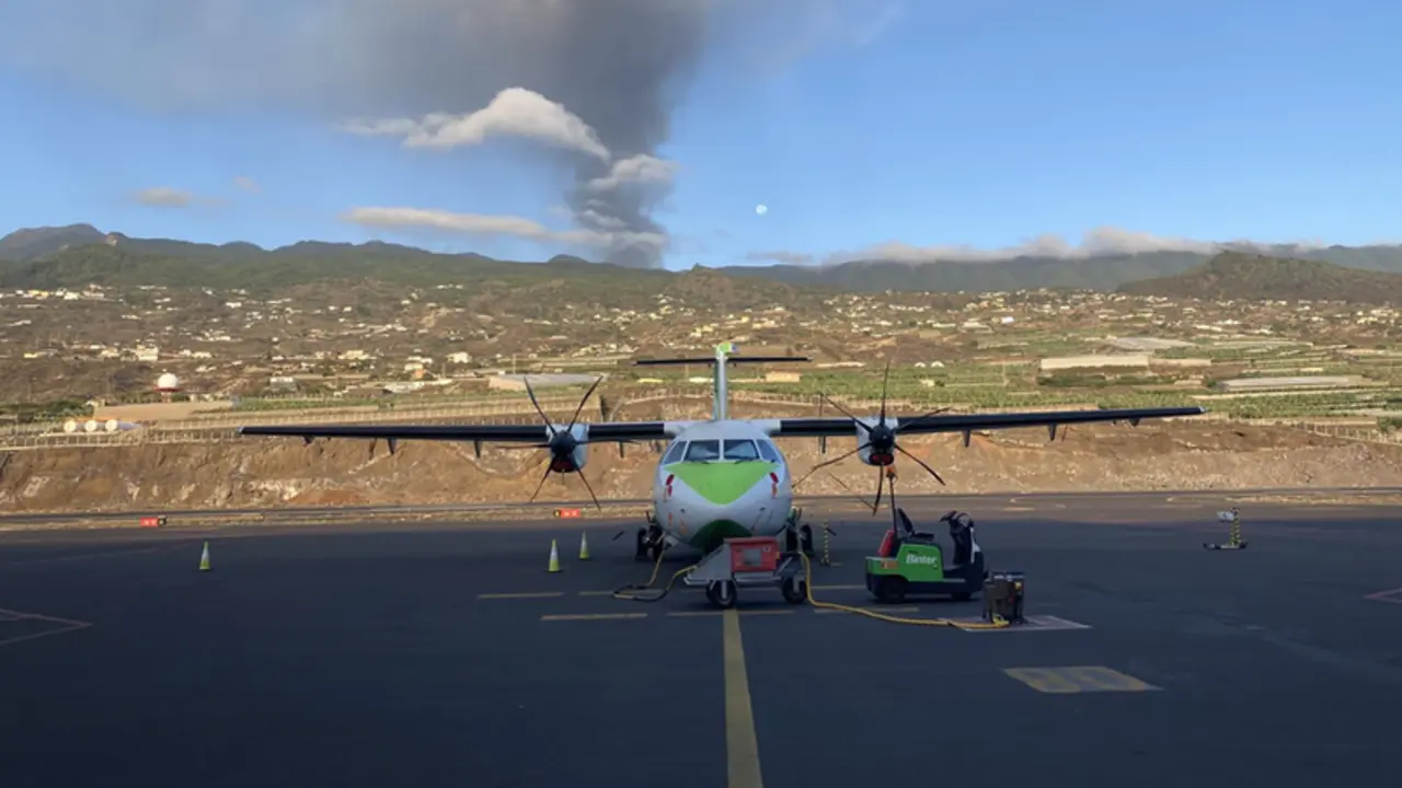 <p> Un avi&oacute;n de Binter en la pista del aeropuerto de La Palma, con el volc&aacute;n en erupci&oacute;n al fondo - BINTER </p>