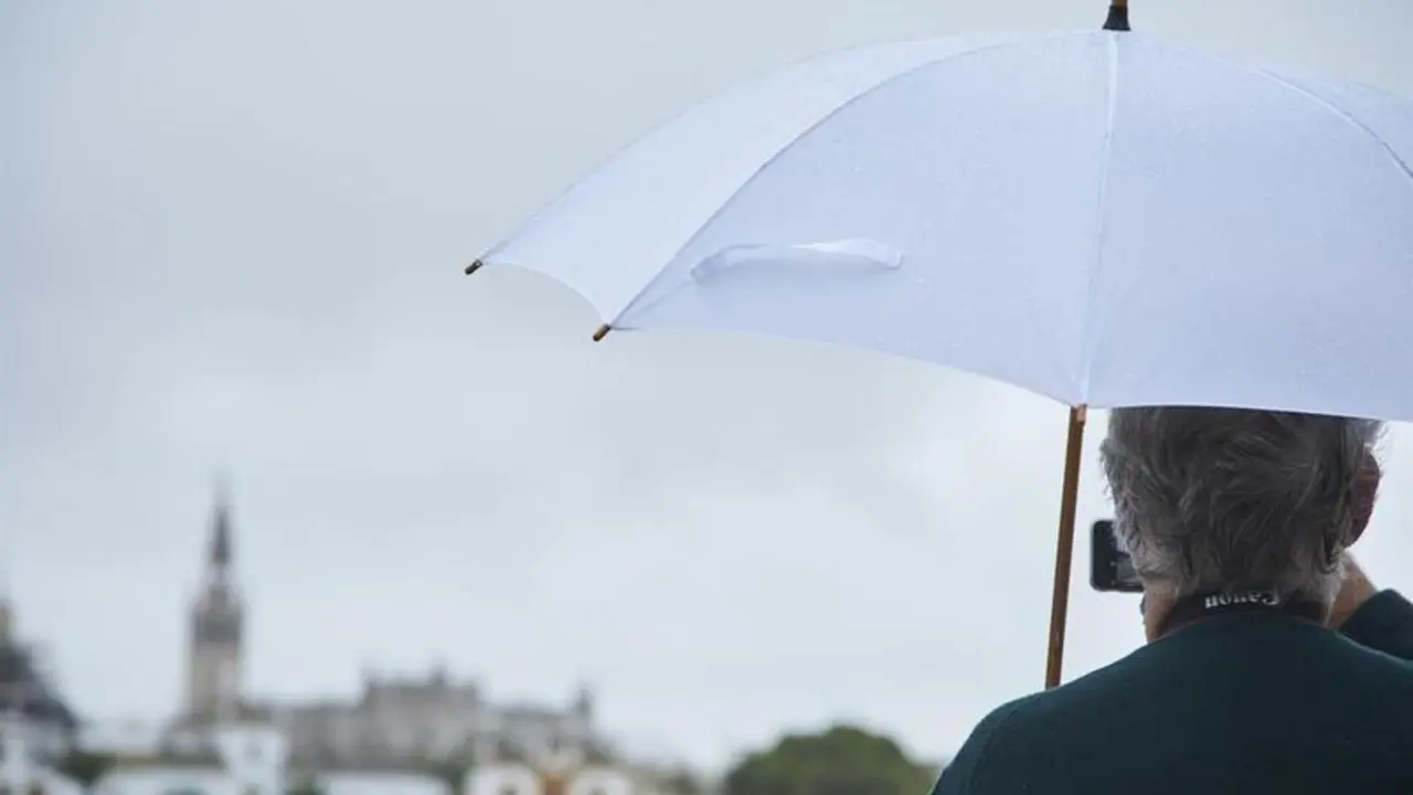 <p> Un se&ntilde;or, bajo su paraguas, toma una foto con su m&oacute;vil del r&iacute;o Guadalquivir en un d&iacute;a lluvioso del puente de Todos los Santos el 30 de octubre de 2021 en Sevilla (Andaluc&iacute;a, Espa&ntilde;a) - Joaquin Corchero - Europa Press </p>