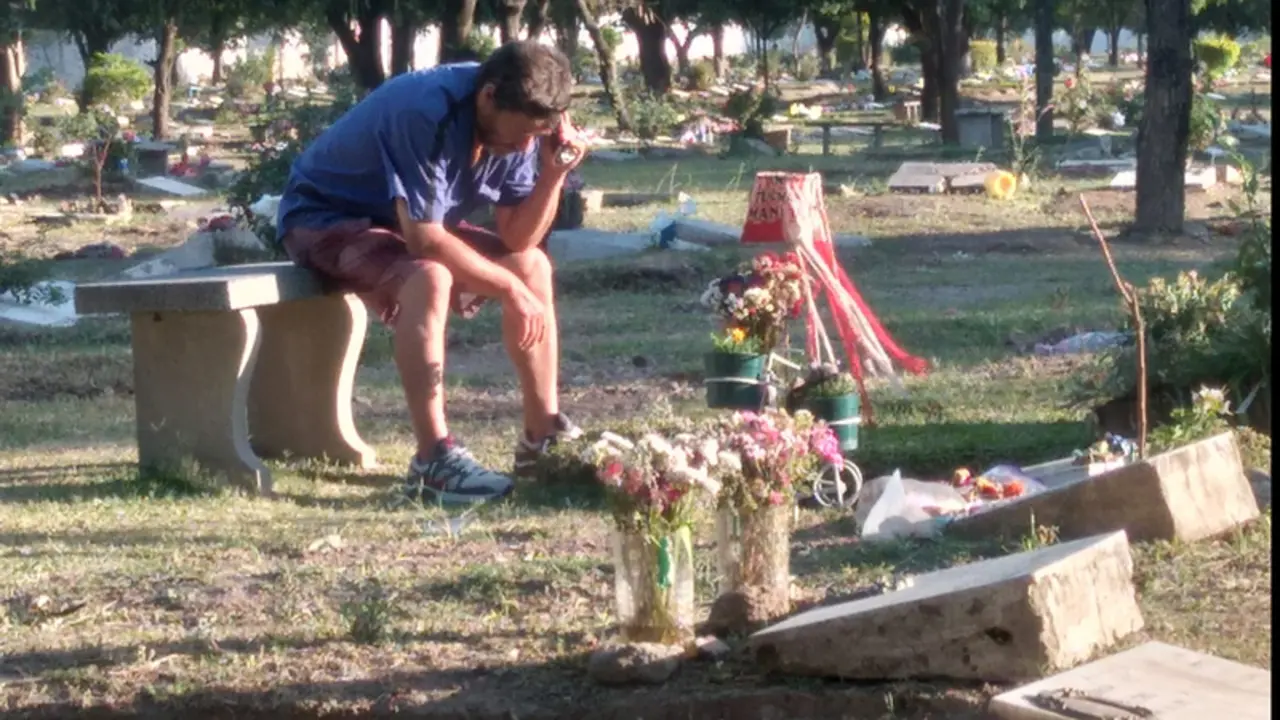 <p> Imagen del momento, el padre junto a la tumba de su hijo </p>
