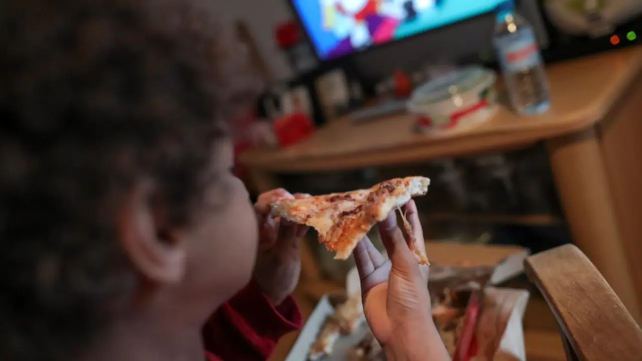 <p> Archivo - Un ni&ntilde;o come un trozo de pizza del men&uacute; infantil de Telepizza mientras ve la televisi&oacute;n en su casa, tras recoger el men&uacute; en un establecimiento de Telepizza. - Jes&uacute;s Hell&iacute;n - Europa Press - Archivo </p>