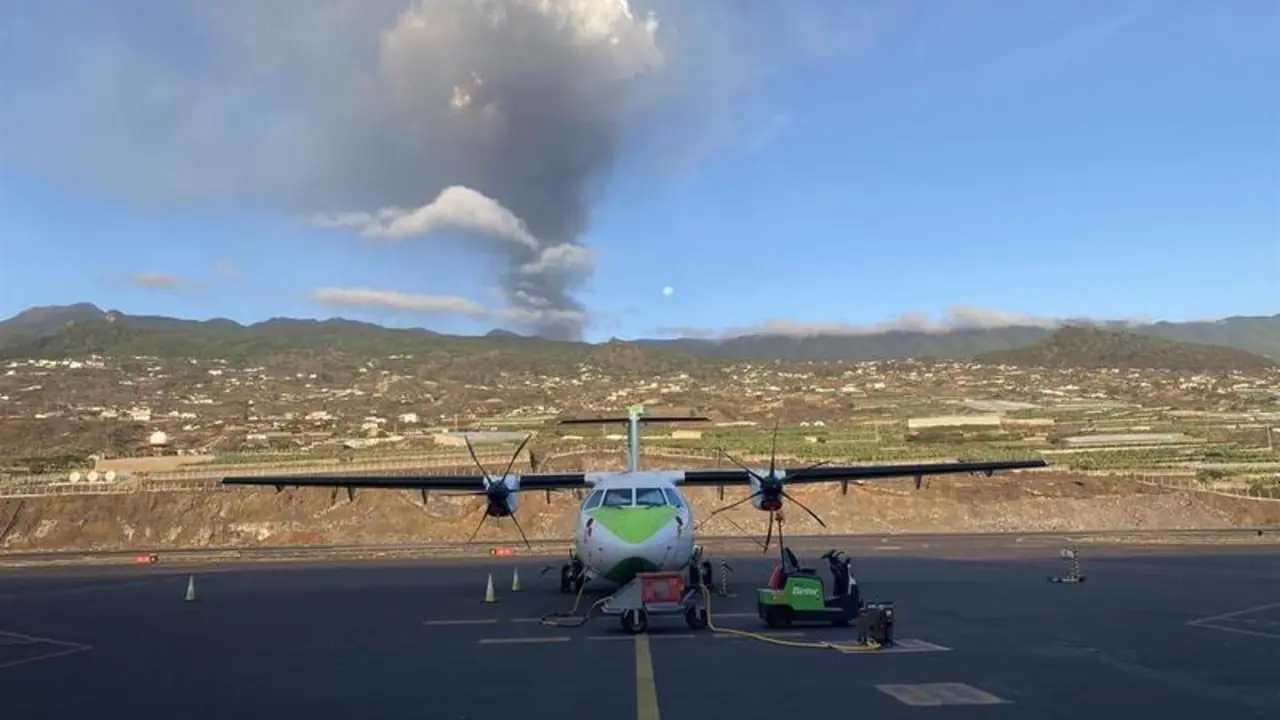 <p> Un avi&oacute;n de Binter en la pista del aeropuerto de La Palma, con el volc&aacute;n en erupci&oacute;n al fondo - BINTER </p>