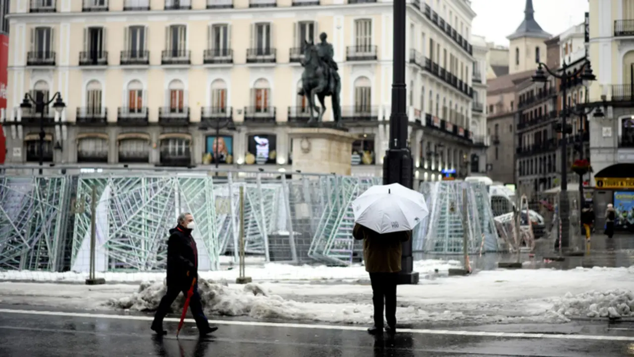 <p> Archivo - Una persona camina protegida por la Puerta del Sol - &Oacute;scar Ca&ntilde;as - Europa Press - Archivo </p>