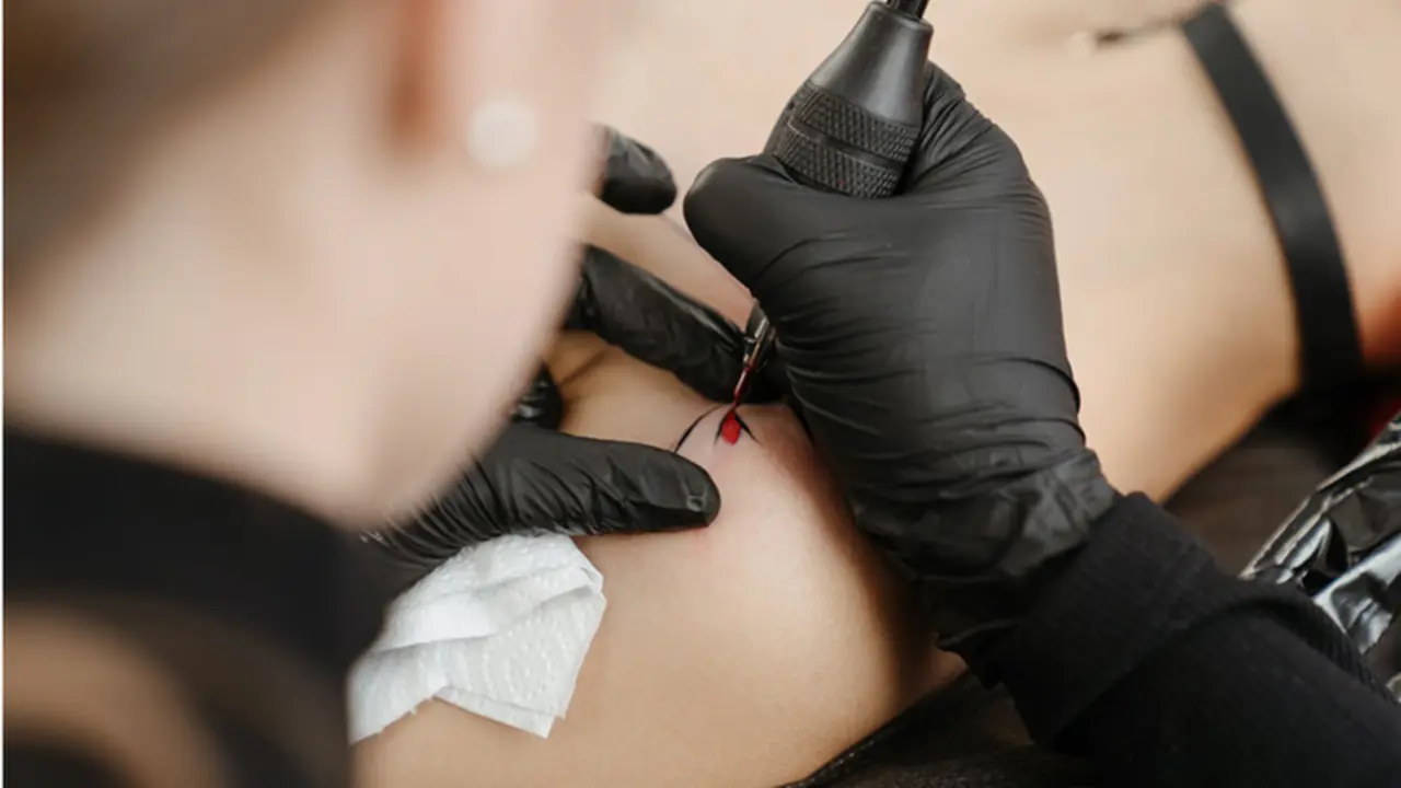 <p> Un profesional realiza un tatuaje sobre la piel de un cliente. </p>