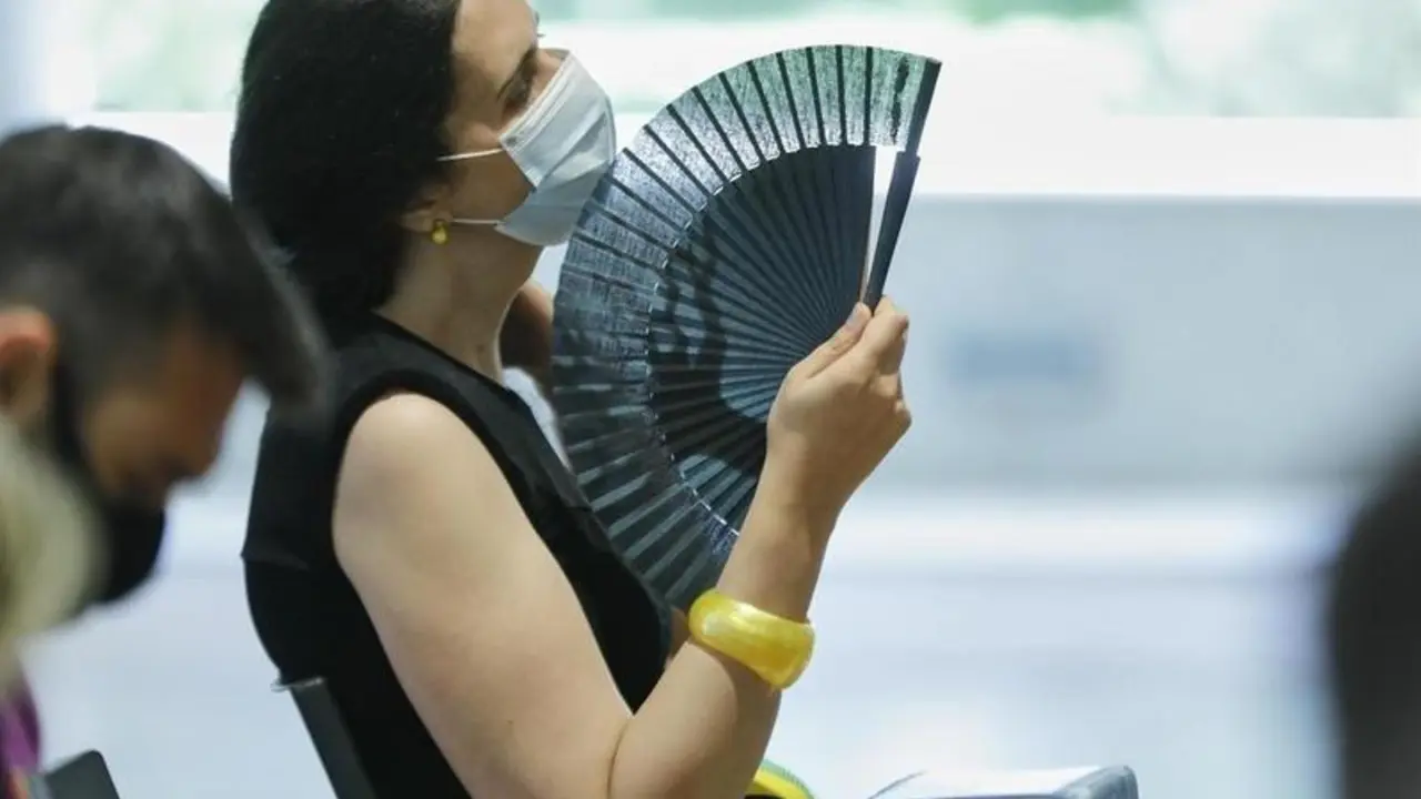 <p> Una mujer con mascarilla se abanica en Madrid - Jes&uacute;s Hell&iacute;n - Europa Press </p>