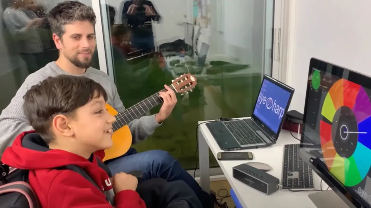 <p> El profesor ayuda a un ni&ntilde;o con discapacidad a hacer m&uacute;sica </p>