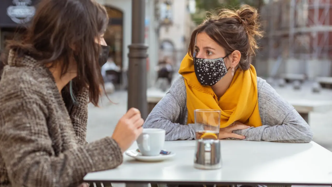 <p> Tomando caf&eacute; en la calle con mascarilla. - WIRESTOCK/FREEPICK </p>
