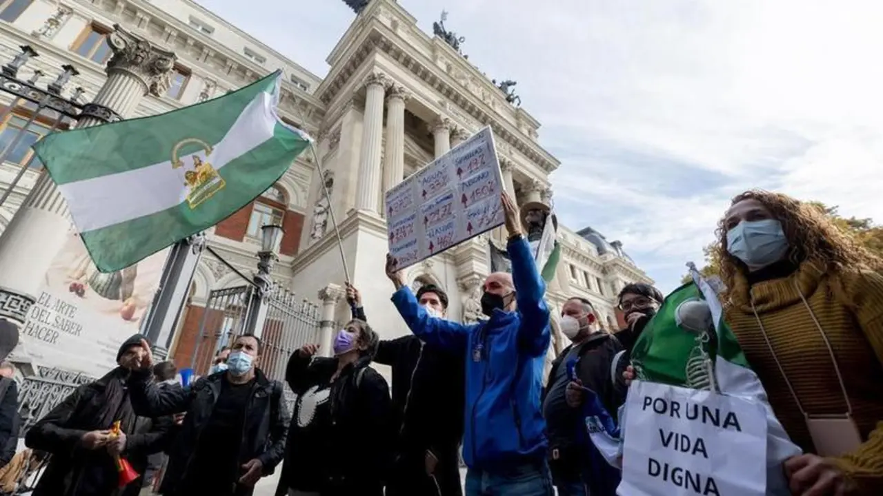 <p> Un grupo de personas con la bandera de Andaluc&iacute;a participa en una concentraci&oacute;n de agricultores y exportadores de naranjas, frente al Ministerio de Agricultura </p>