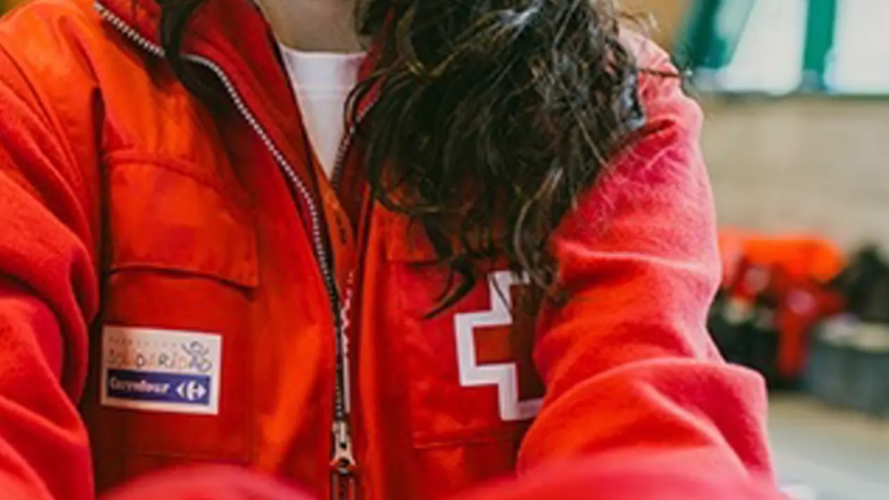 <p> Una voluntaria entrega un chaleco de Cruz Roja - FUNDACI&Oacute;N SOLIDARIDAD CARREFOUR </p>