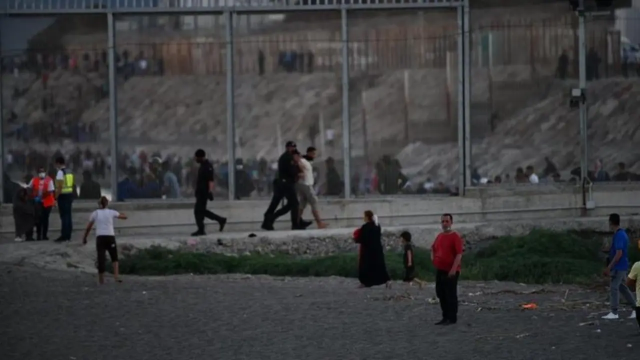 <p> Agentes de Polic&iacute;a y personas migrantes en la playa del Tarajal (Ceuta). EP </p>