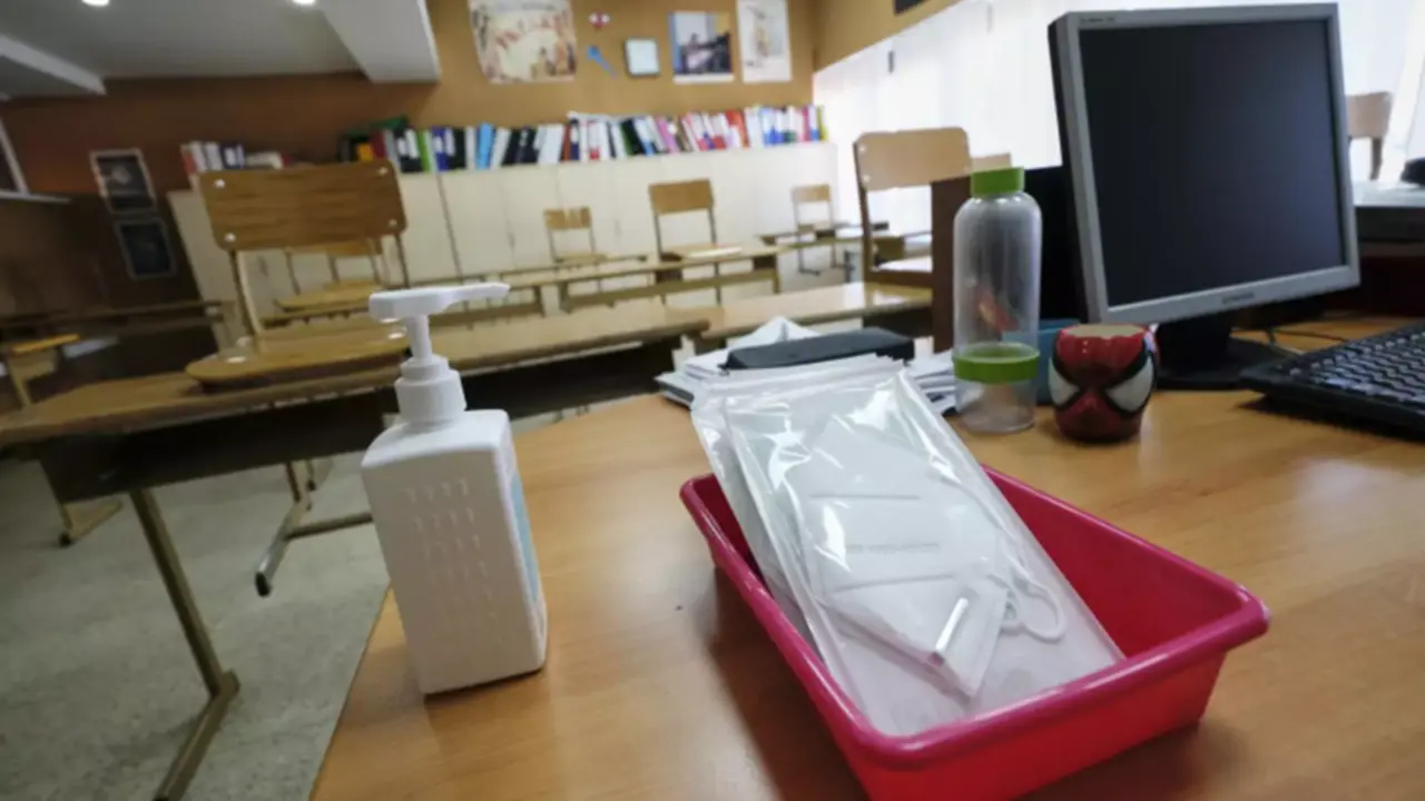 <p> Mascarillas y gel desinfectante en la mesa del profesor de un aula. Fuente: Europa Press </p>