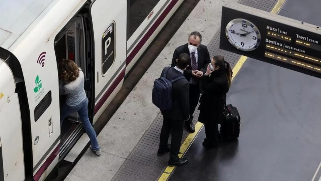 <p> Varias personas, con maletas, en el and&eacute;n antes de coger un tren de alta velocidad </p>