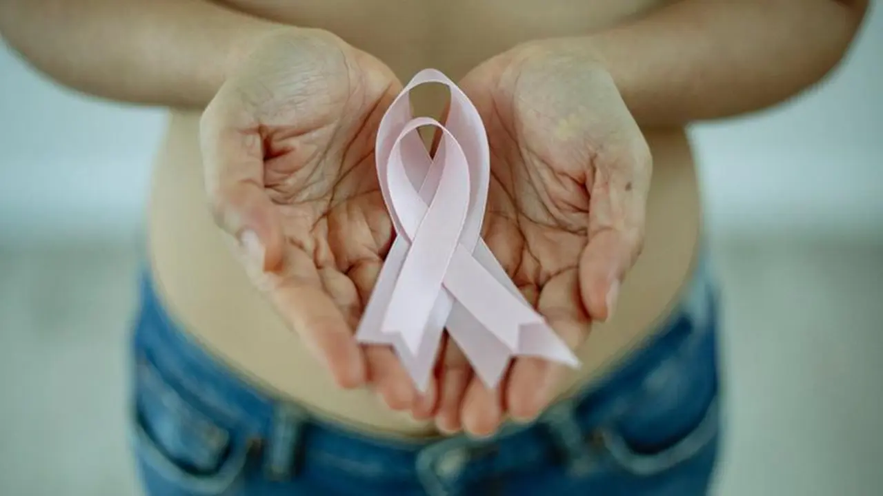 <p> Mujer portando lazos de color rosa para la concienciaci&oacute;n sobre el c&aacute;ncer de mama </p>