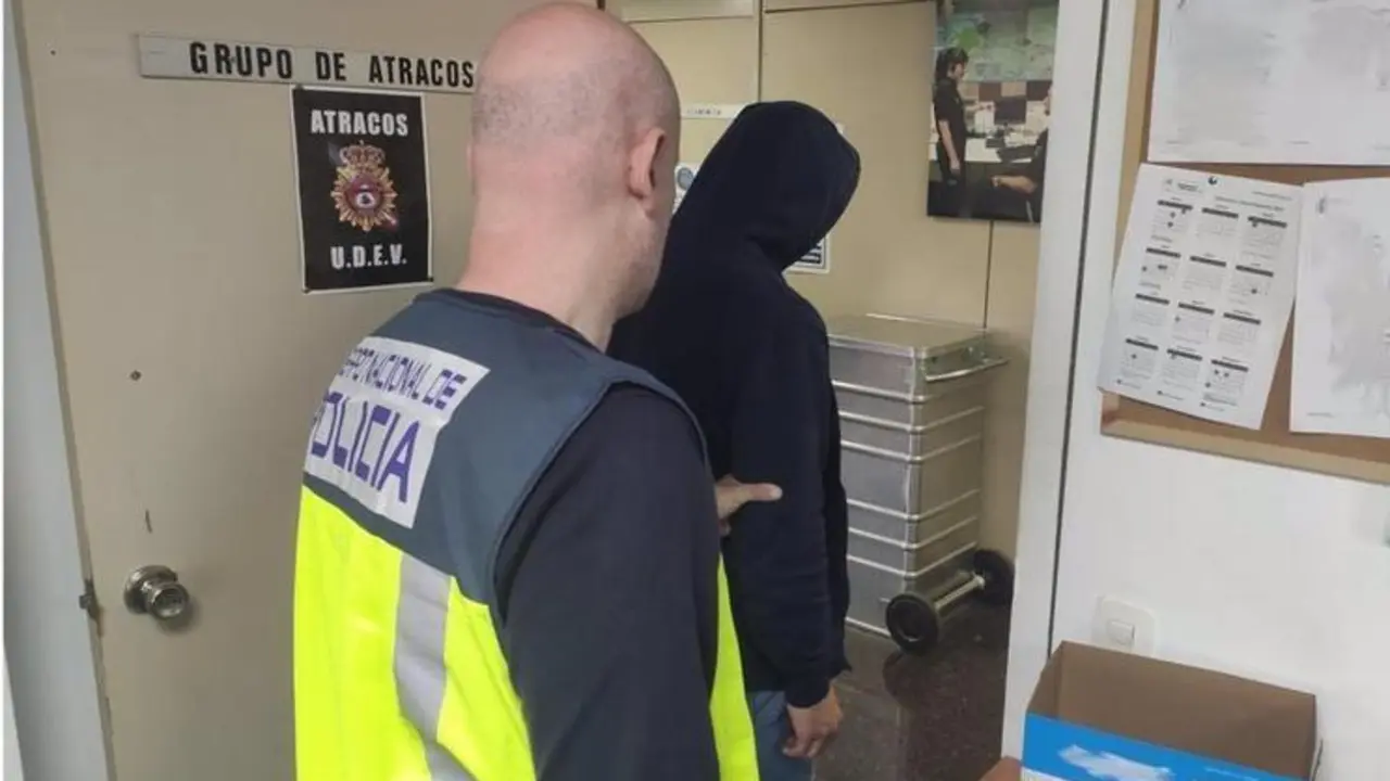 <p> Uno de los arrestados, conducido por uno de los agentes </p>