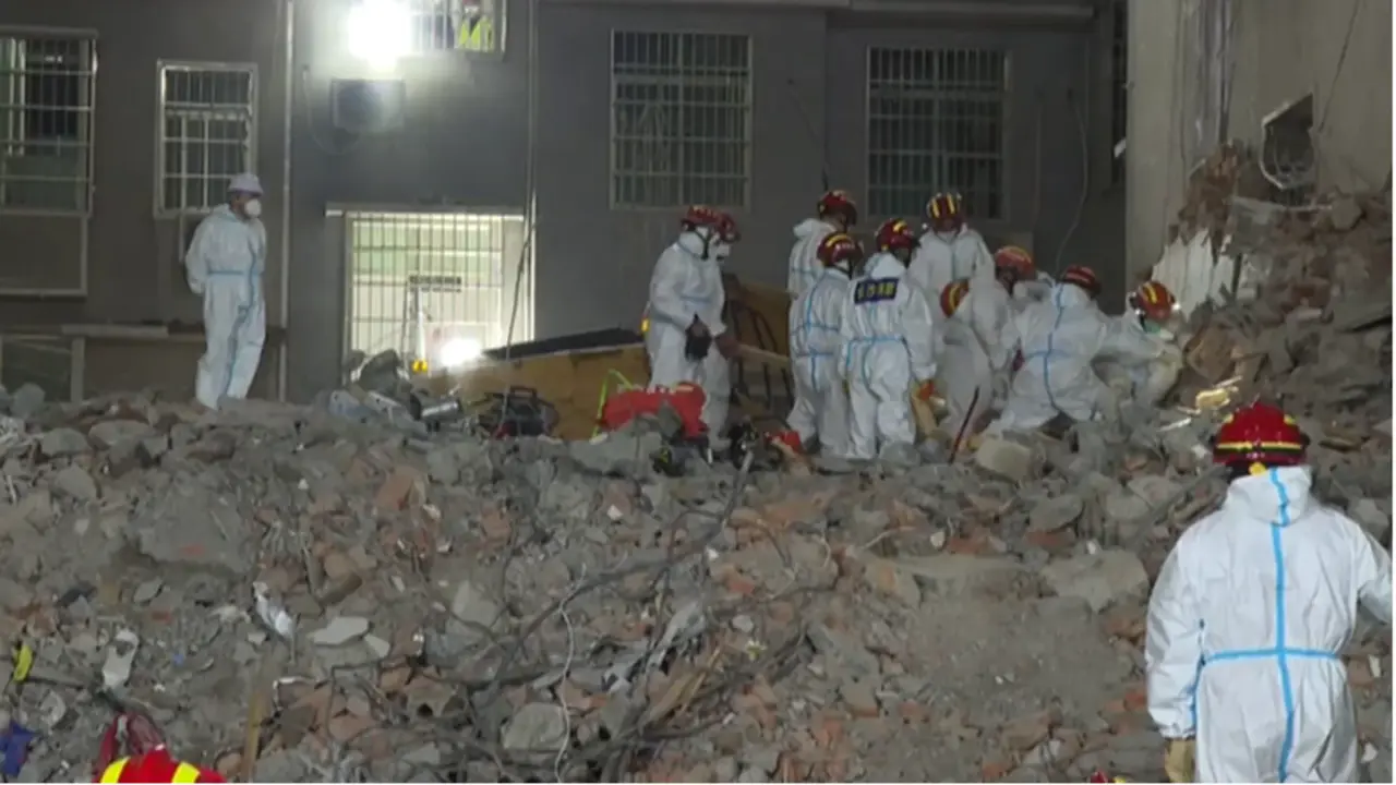 <p> Los servicios de rescate chino buscando supervivientes entre los escombros del edificio </p>