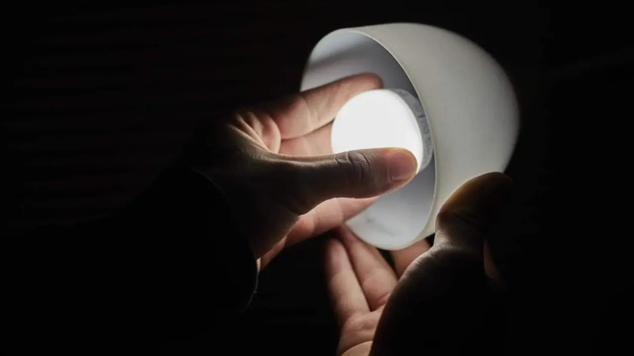 <p> Un hombre cambia la bombilla de una l&aacute;mpara </p>