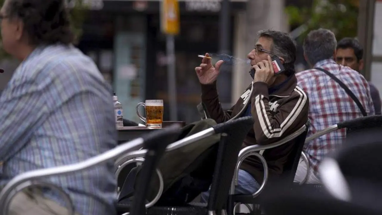 <p> Una persona fumando en una terraza </p>