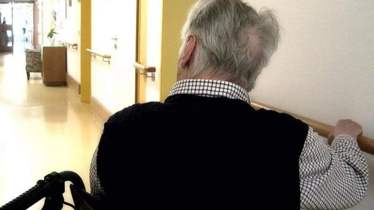 <p> Una persona en silla de ruedas se desplaza por los pasillos de una residencia de mayores. EUROPA PRESS </p>