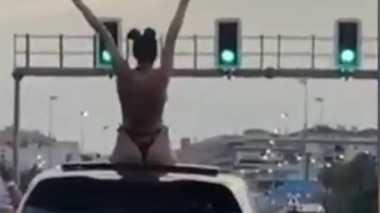 <p> La mujer bailando en bikini sobre el coche </p>