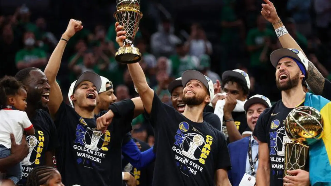 <p> Stepehn Curry levantando el t&iacute;tulo de MVP de las finales, mientras Klay Thompson sostiene el trofeo de campeones </p>