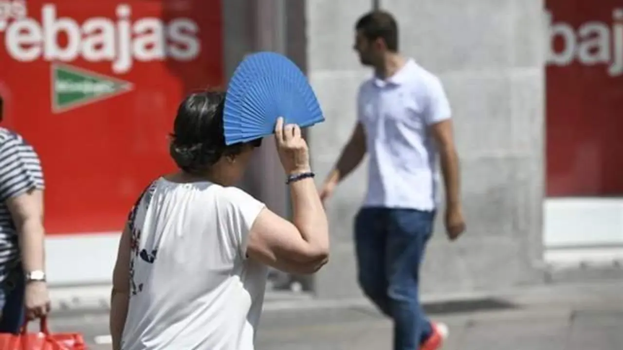 <p> Se&ntilde;ora utiliza el abanico para intentar taparse del sol y del calor. Twitter </p>