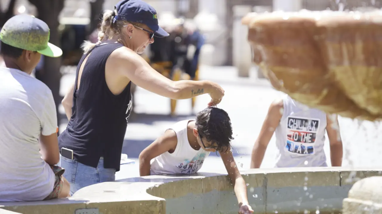 <p> Una madre le echa agua a su hijo, por la cabeza, en la fuente de la plaza Virgen de los Reyes en el primer d&iacute;a de la segunda ola de calor, a 7 de julio de 2022 en Sevilla (Andaluc&iacute;a, Espa&ntilde;a) - Joaquin Corchero - Europa Press </p>