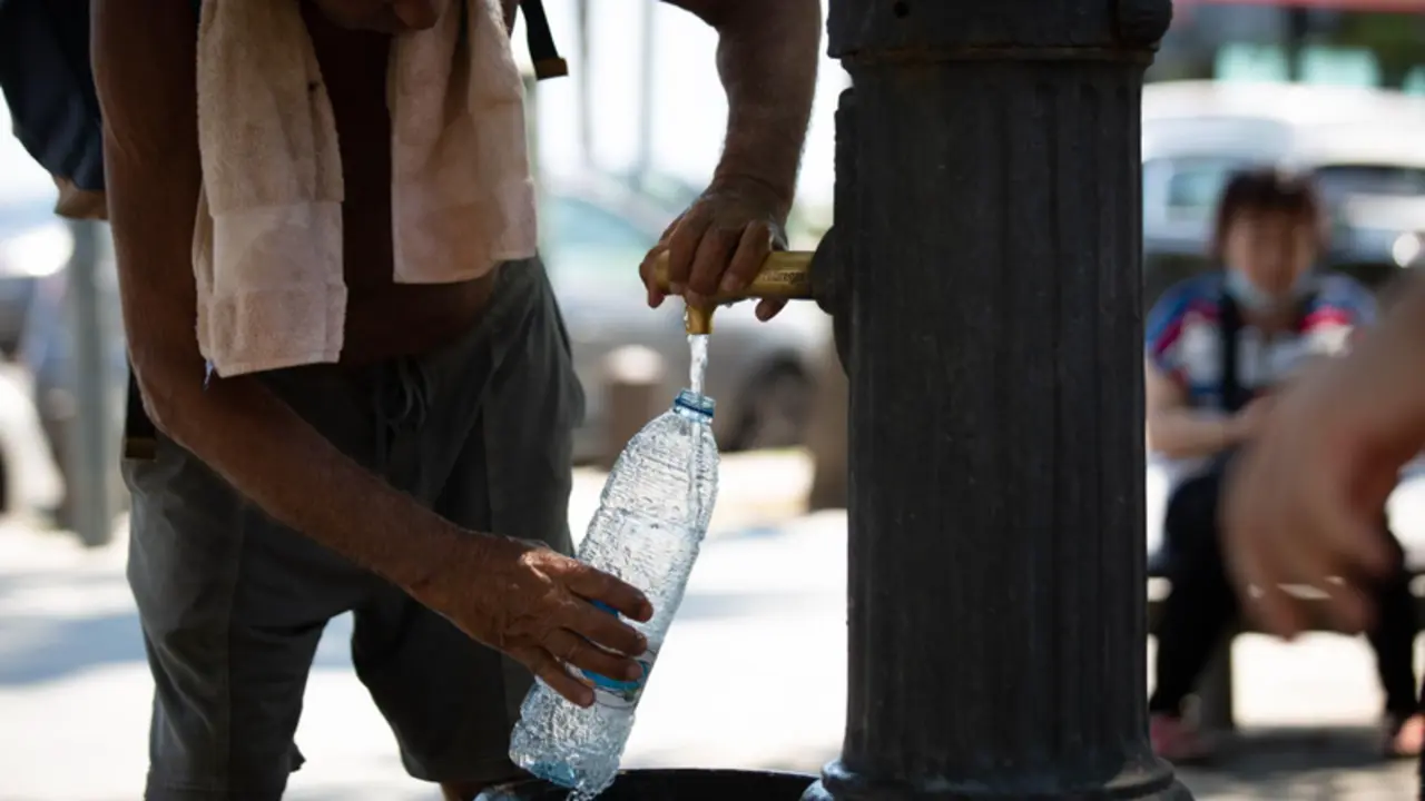 <p> Un hombre rellena una botella de agua en una fuente en el parque de la Barceloneta, a 13 de julio de 2022, en Barcelona - David Zorrakino - Europa Press </p>