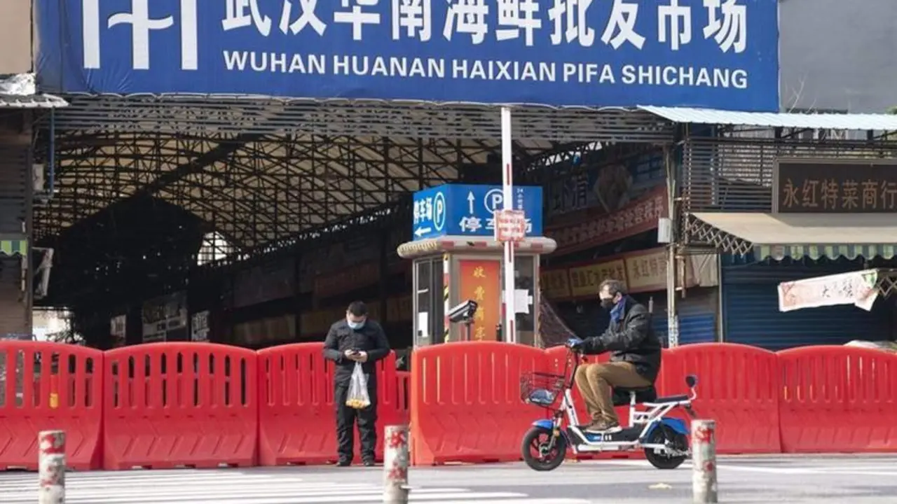 <p> Dos ciudadanos pasan por la entrada del mercado de mariscos Huanan en Wuhan, provincia de Hubei, en el centro de China, el 29 de enero </p>