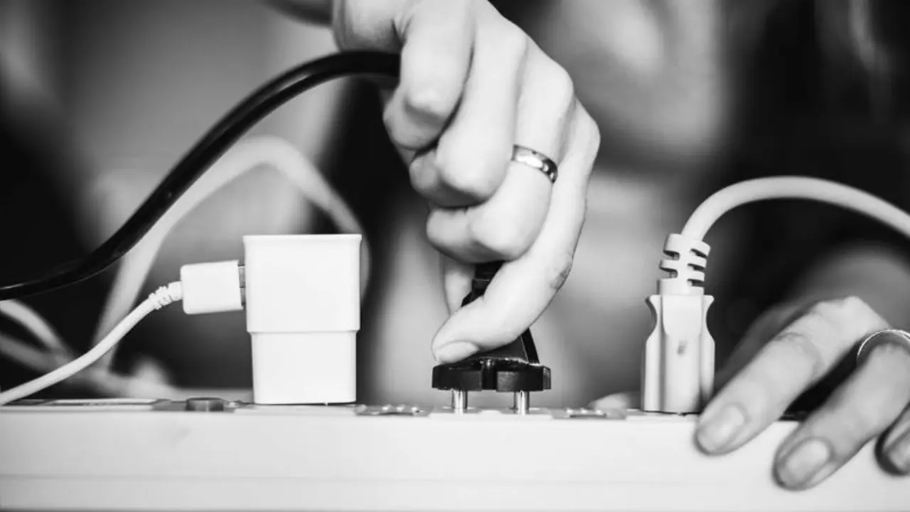 <p> Mujer enchufando un cable </p>