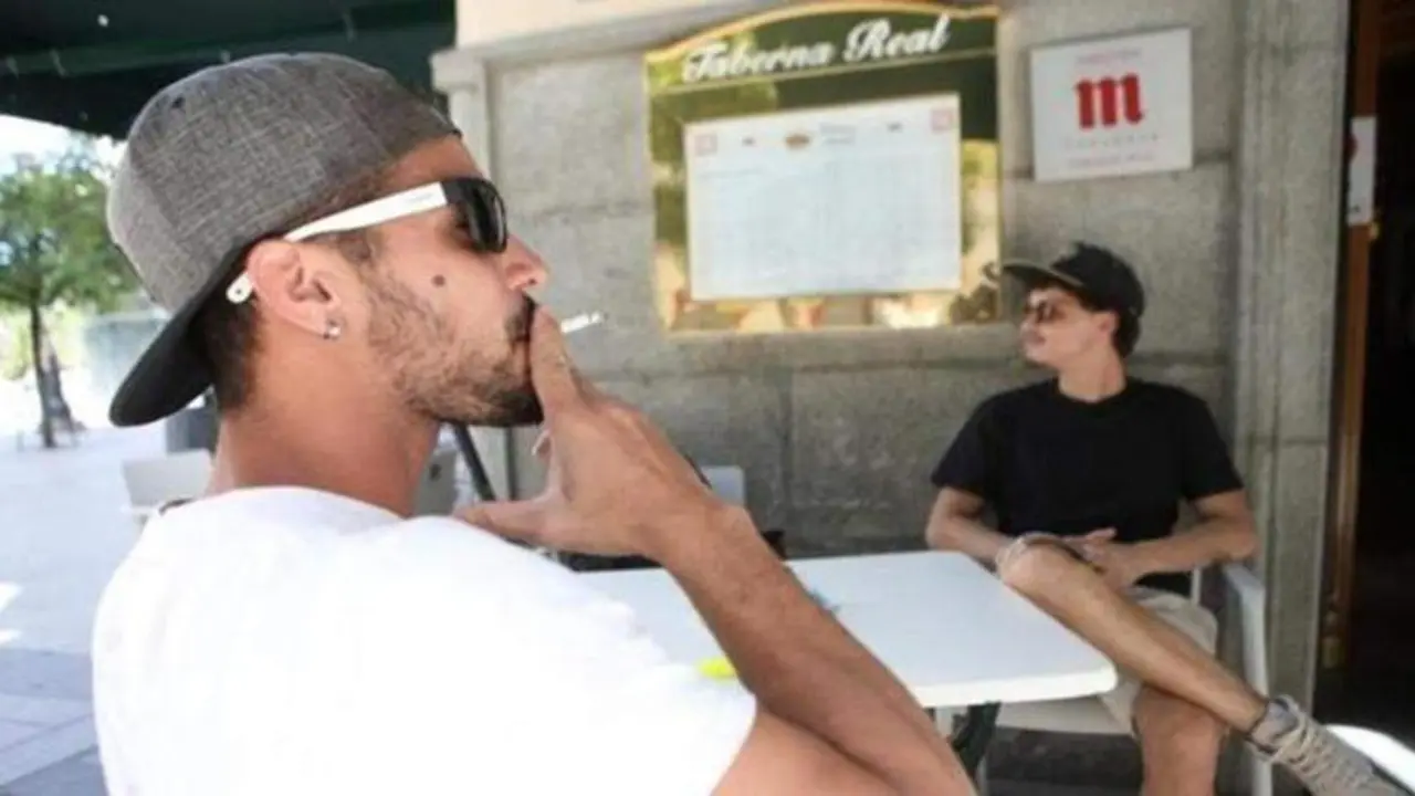 <p> Hombre fumando en una terraza de bar </p>