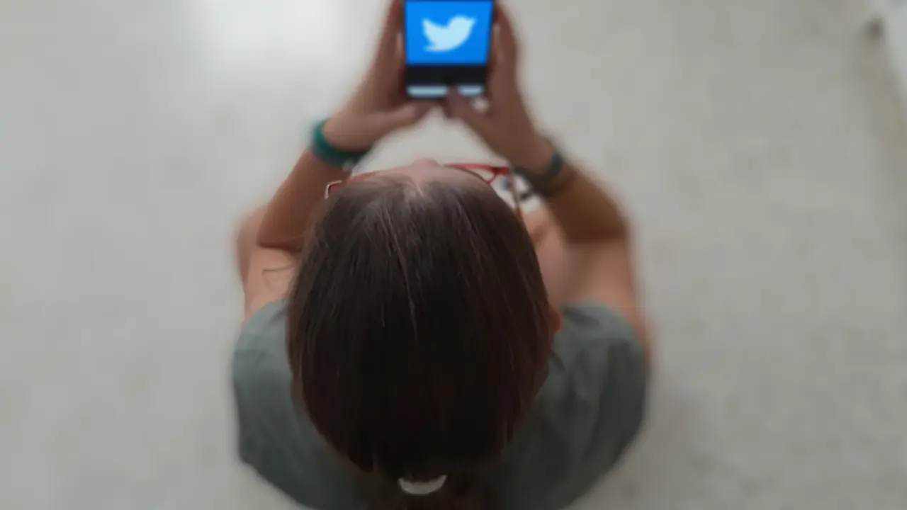 <p> Una adolescente revisa un tel&eacute;fono m&oacute;vil. </p>