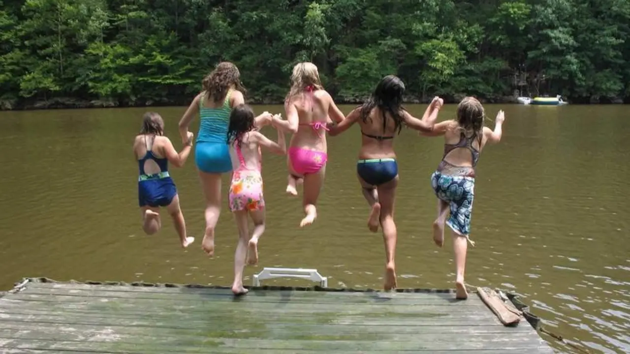 <p> Chicas saltando a un lago </p>