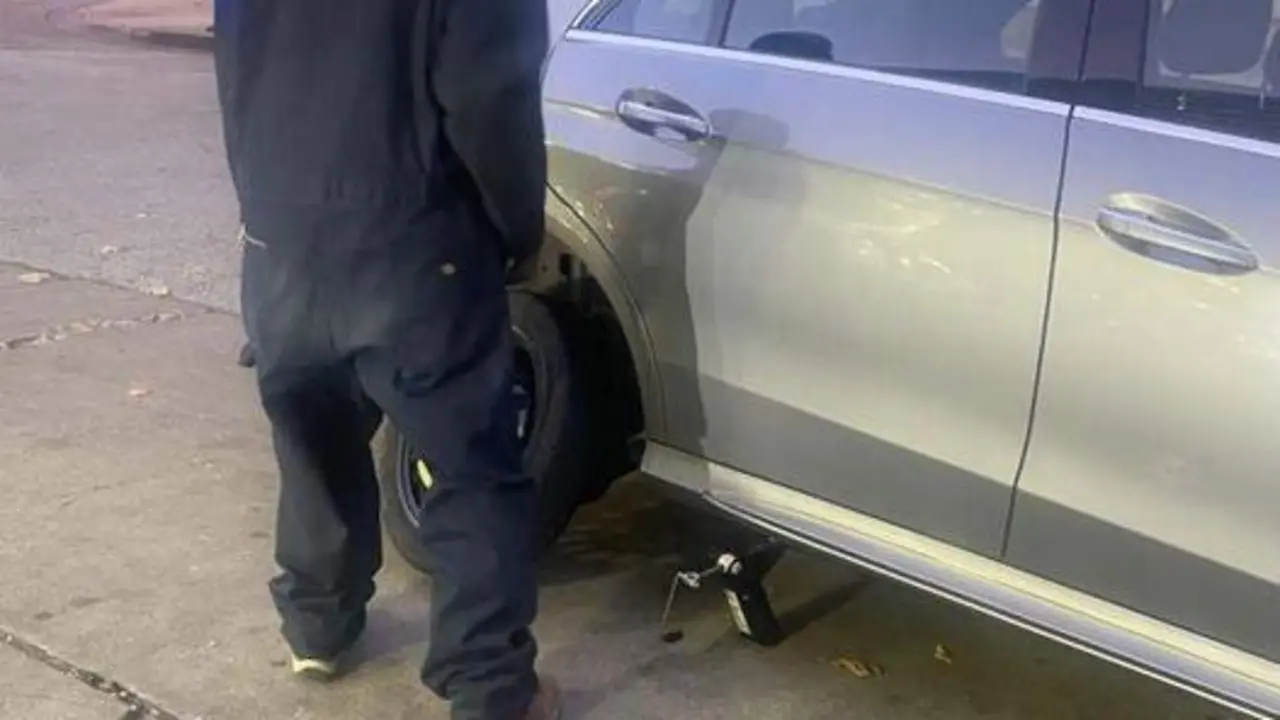 <p> El hombre sin hogar ayudando a la mujer a cambiar la rueda </p>