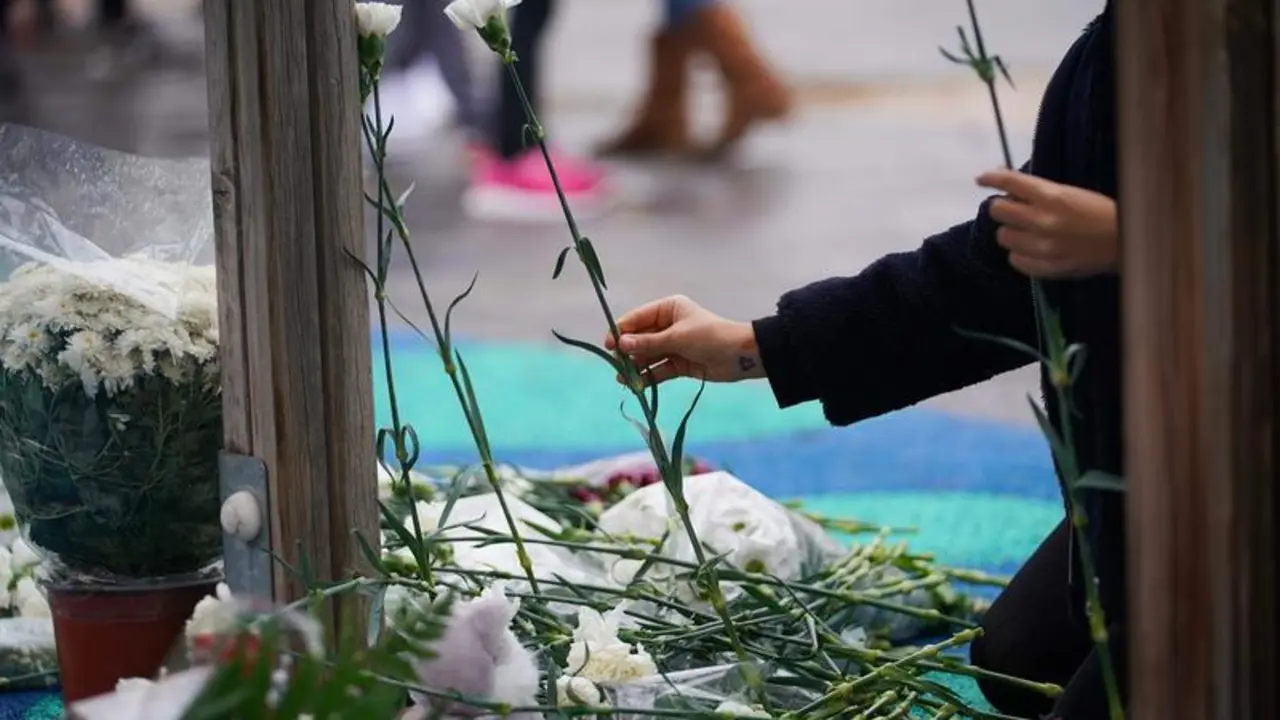  Un ni&ntilde;o deposita flores en el parque donde fue secuestrado un menor de 9 a&ntilde;os, que despu&eacute;s fue asesinado, en Lardero, La Rioja 