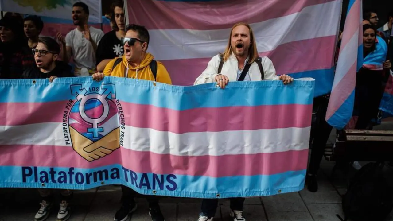  Varias personas con banderas trans durante una concentraci&oacute;n de la Federaci&oacute;n Plataforma Trans 