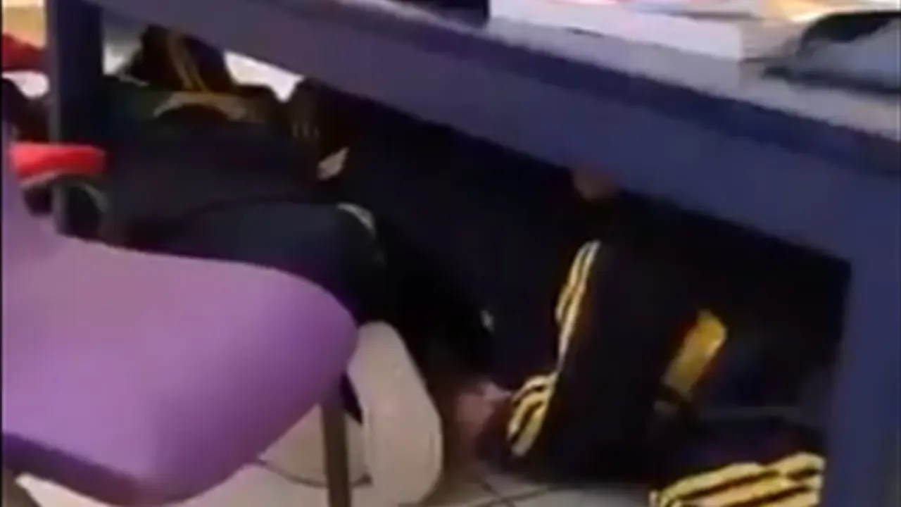  Los alumnos resguardados bajo las mesas 