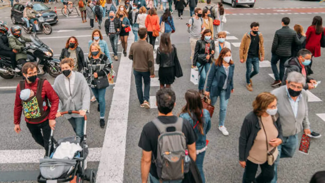 Barcelona, Spain - APR 23 2021: Crowd walking in Rambla Catalunya on Sant Jordi day. Sant Jordi's festivity is a catalan tradition where people buy books and red roses to give each other. This day the streets of Barcelona were crowded with people wearing masks because of Covid-19