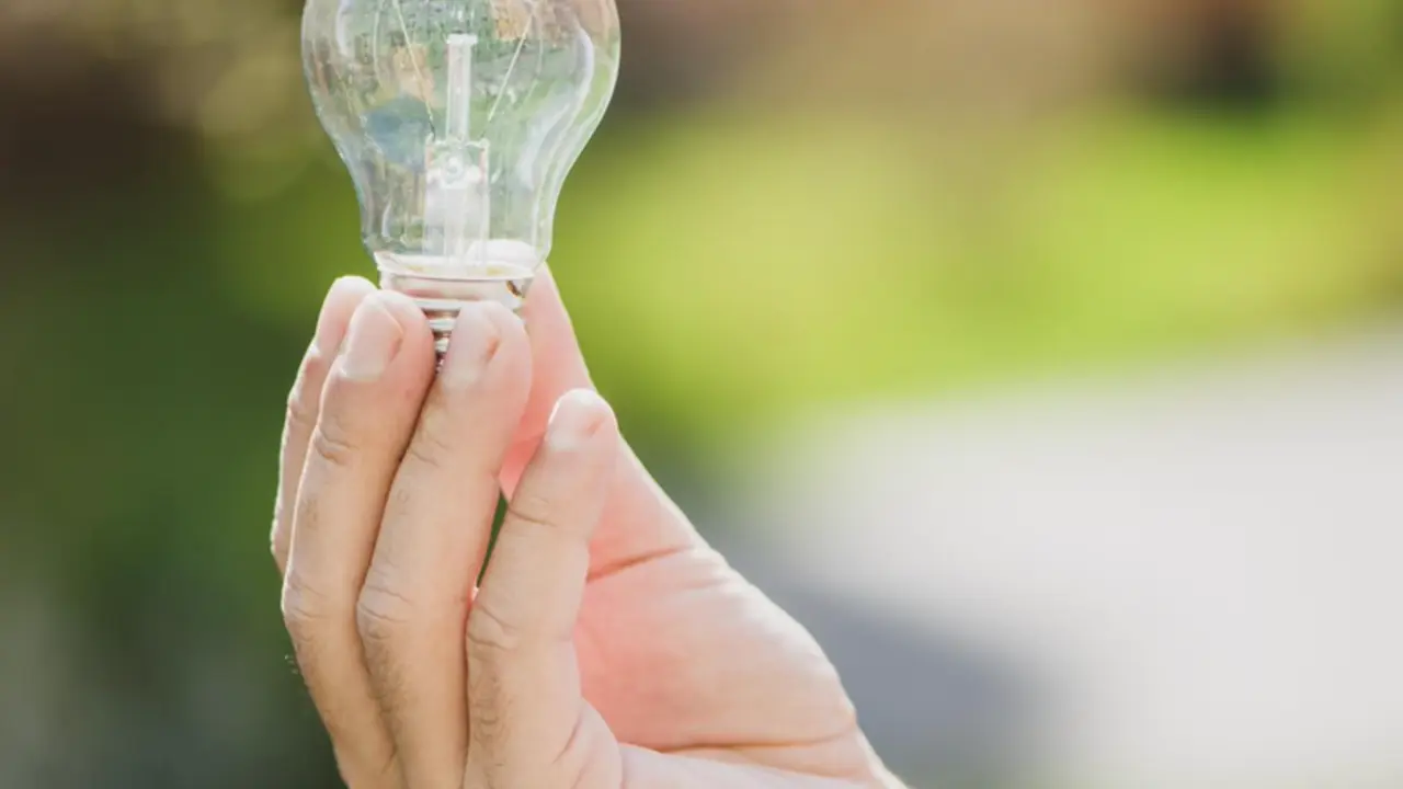  Archivo - Una persona sostiene una bombilla. - ENDESA - Archivo 