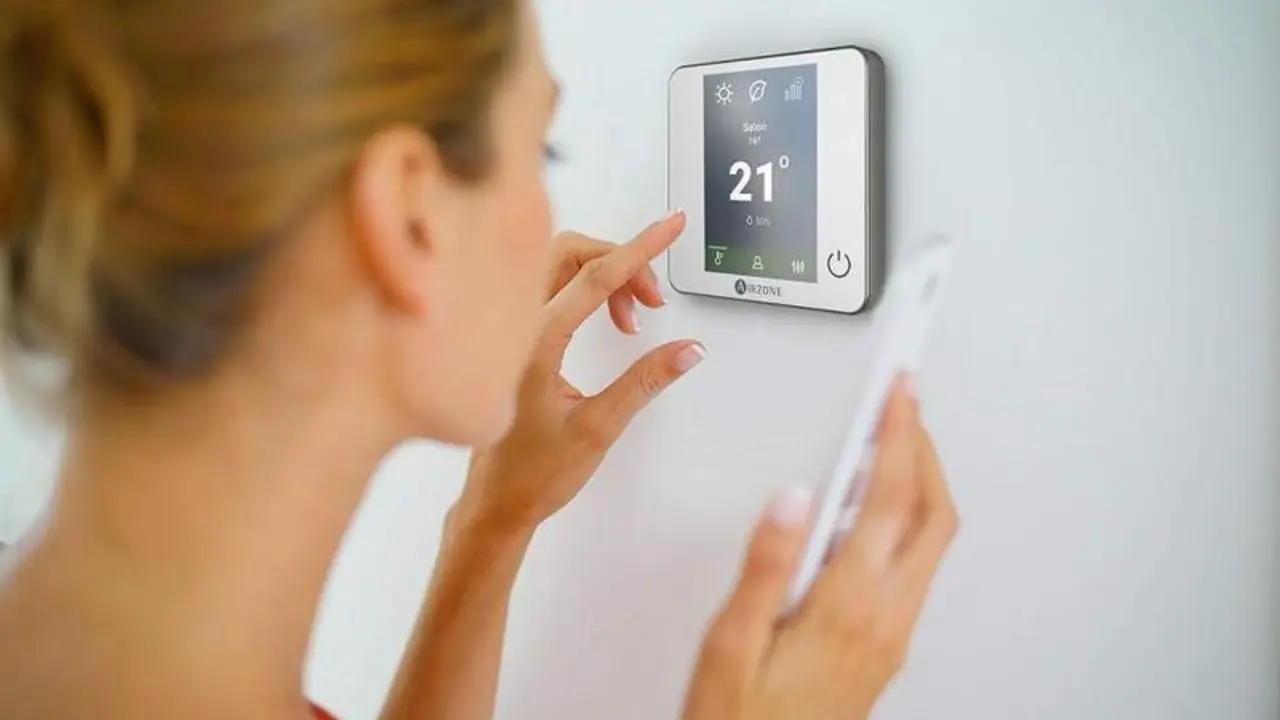  Una mujer regula el termostato 