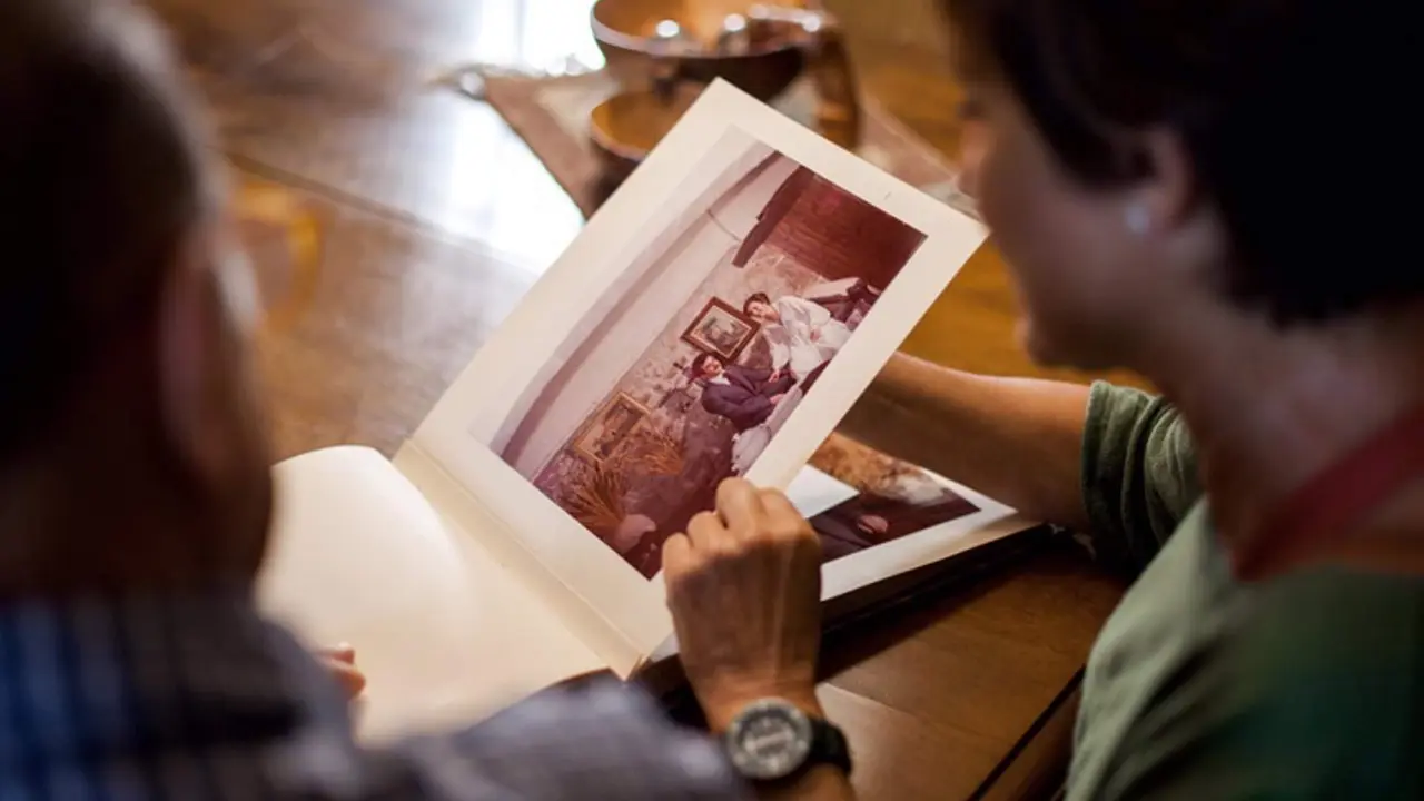  First point of view of a senior man and woman looking at a old wedding photo album. Remembering the past. Mature love. Top shot. Indoor, daytime. 
