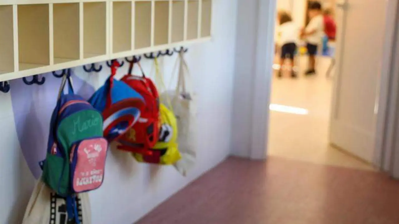  Varias mochilas en una percha de un aula de 0 a 3 a&ntilde;os de un colegio 
