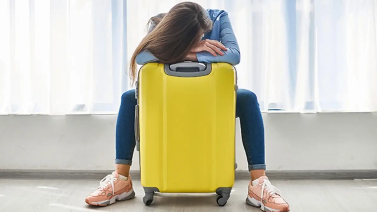  Mujer junto a una maleta. OCU 