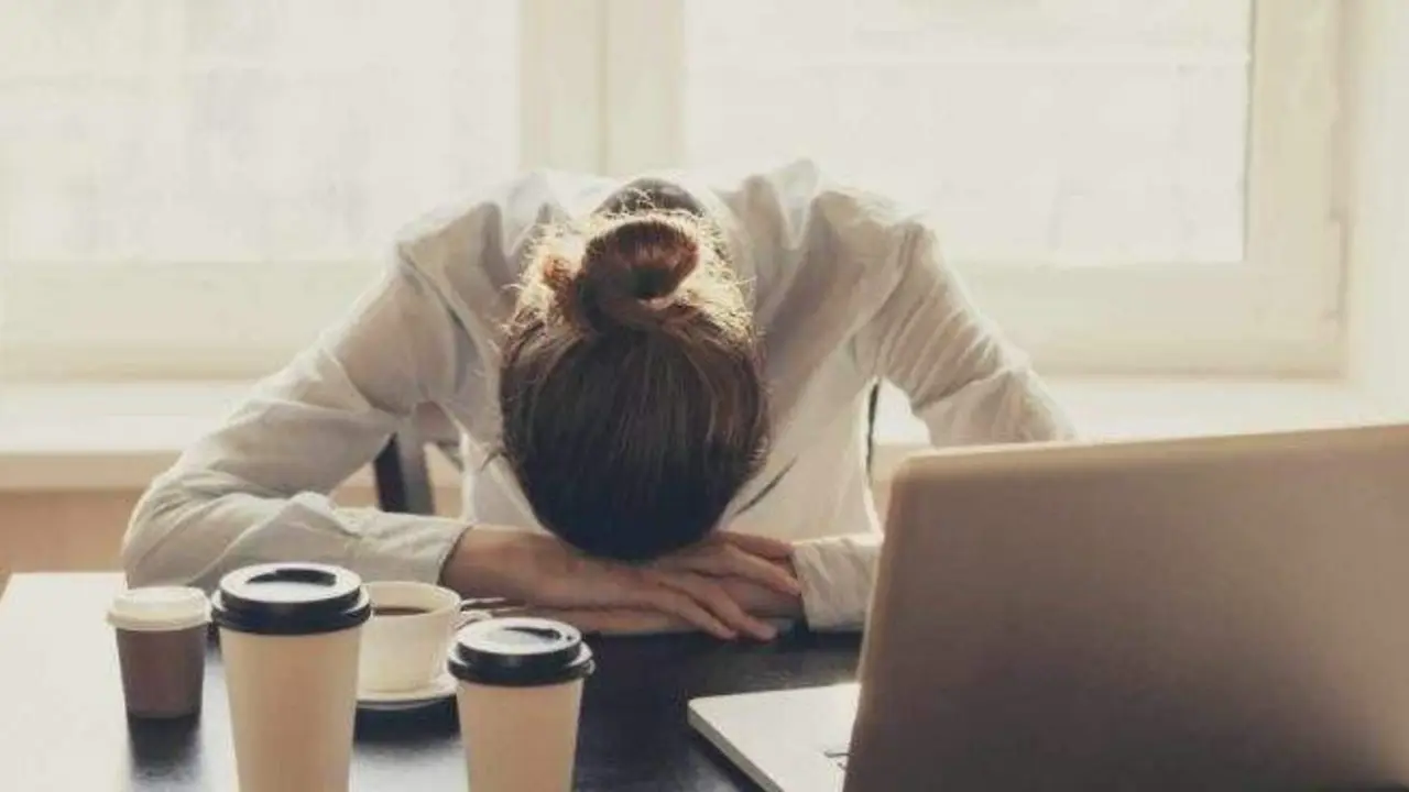  Trabajadora agobiada frente al port&aacute;til 