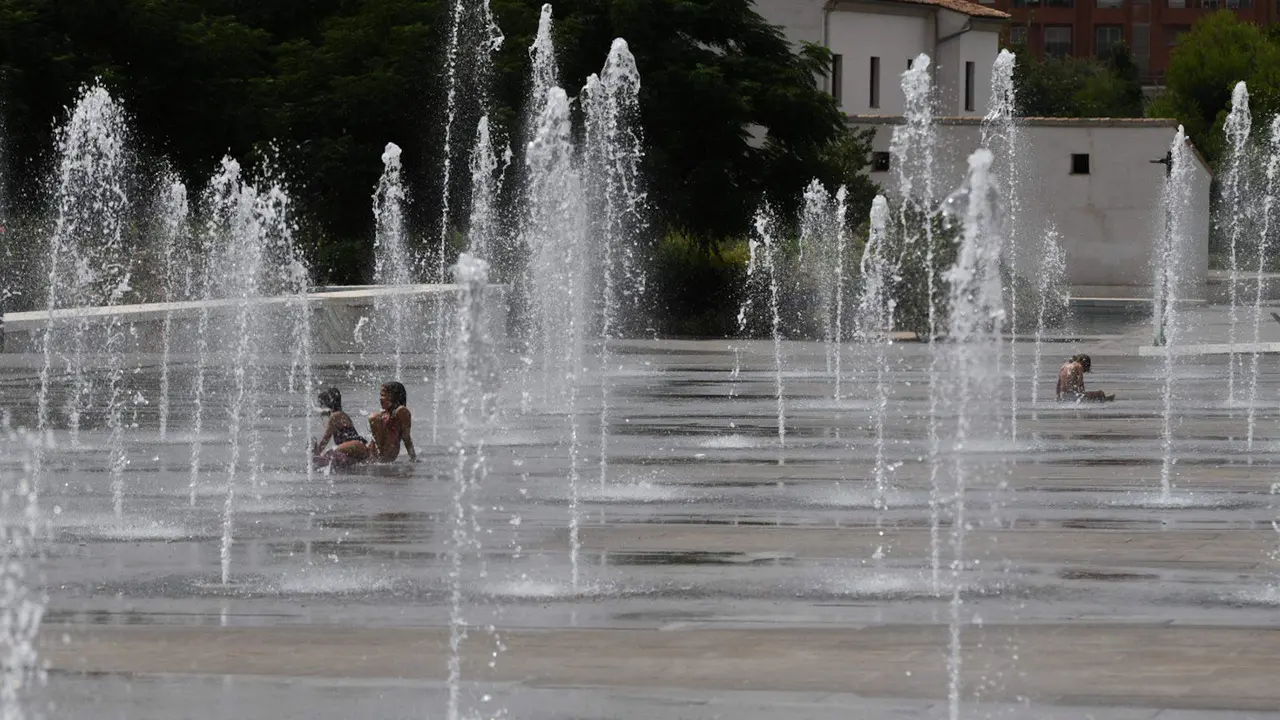  Varios ni&ntilde;os se refrescan en una fuente 