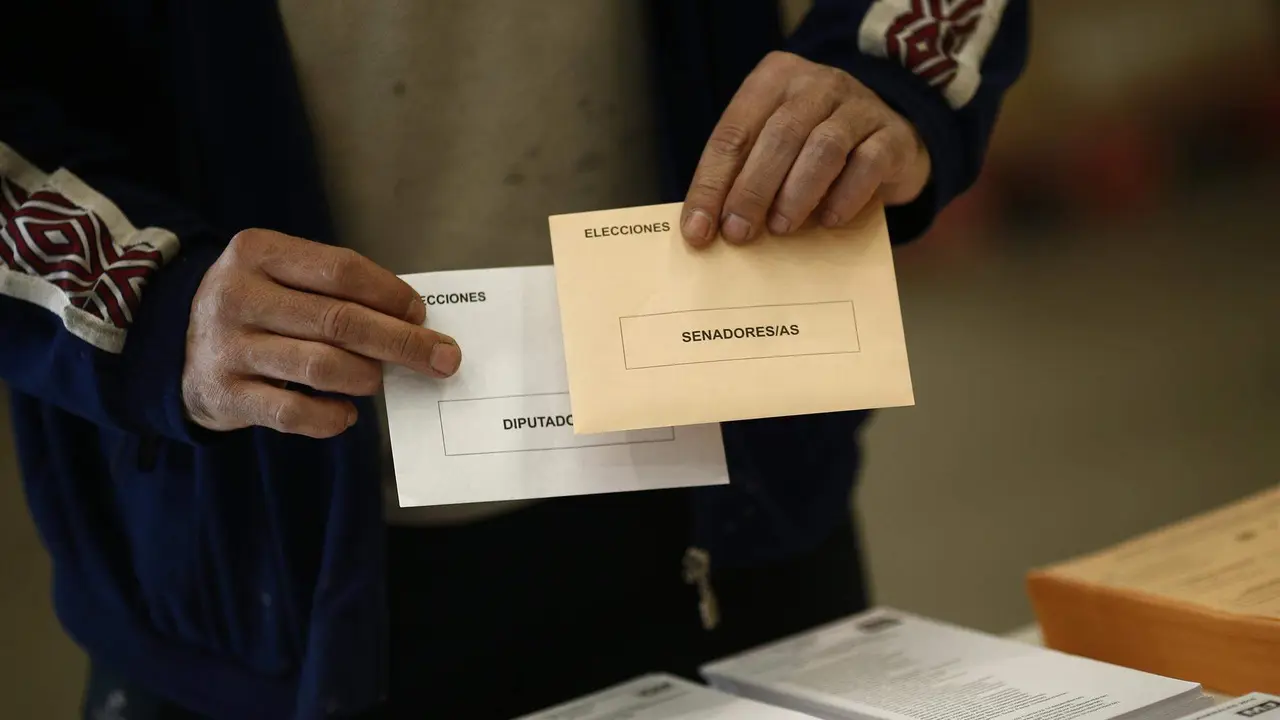  Un elector sostiene sus sobres de vortaci&oacute;n para las generales 