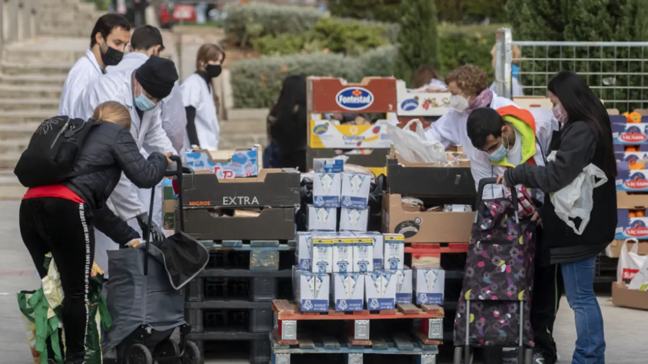  Varias personas recogen comida de la Fundaci&oacute;n Madrina. 