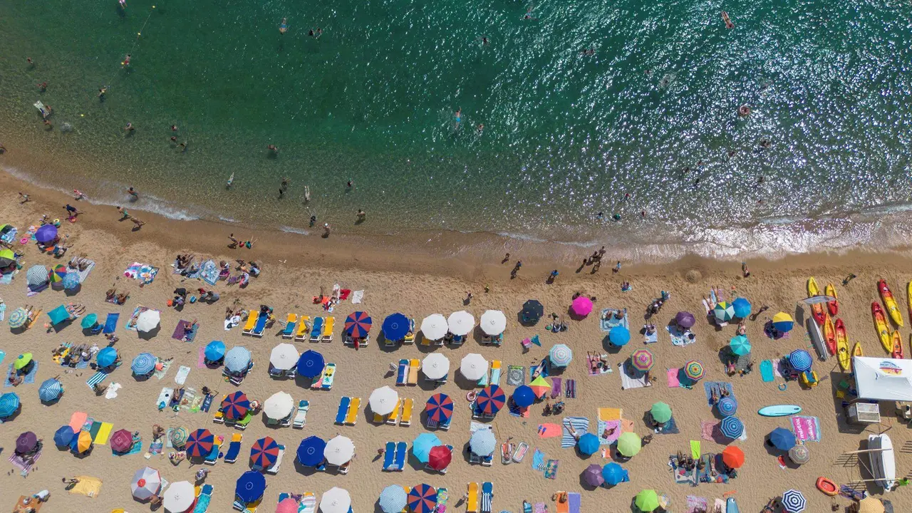  Numerosas personas disfrutan de un d&iacute;a de playa en la Costa Brava, en Tossa de Mar, Girona, Catalu&ntilde;a 