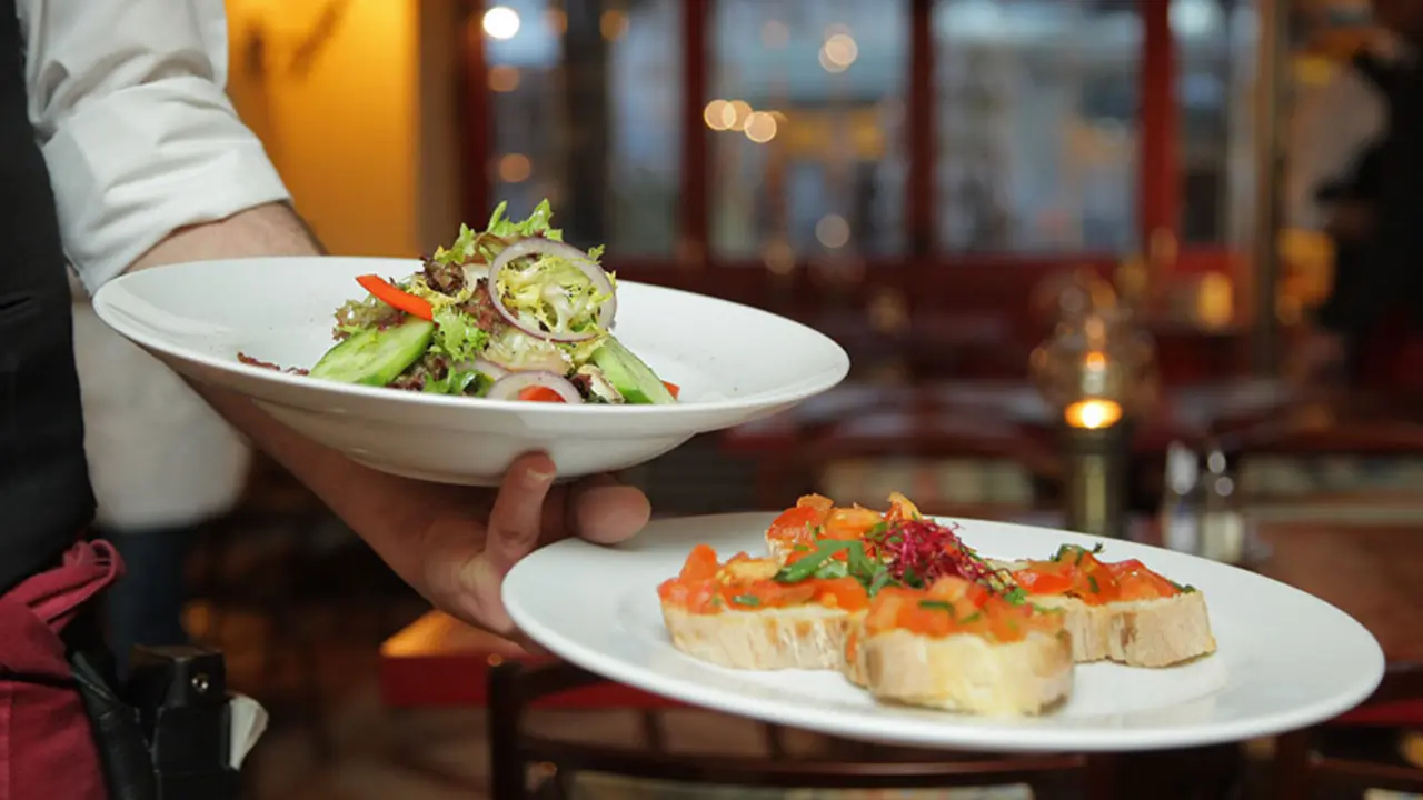  Un camarero muestra dos platos en un restaurante. 