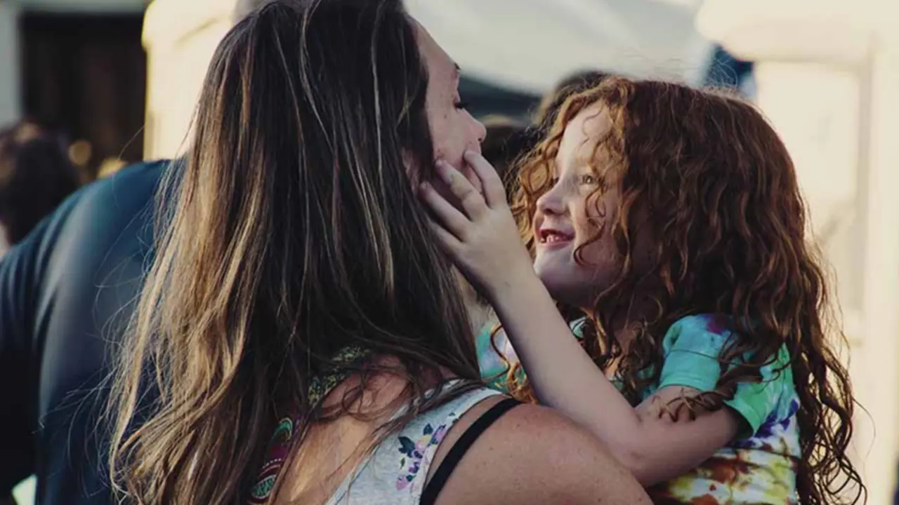  Una mujer abraza a una ni&ntilde;a. 