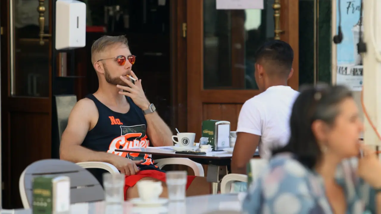  Personas fumando en terraza. EP 