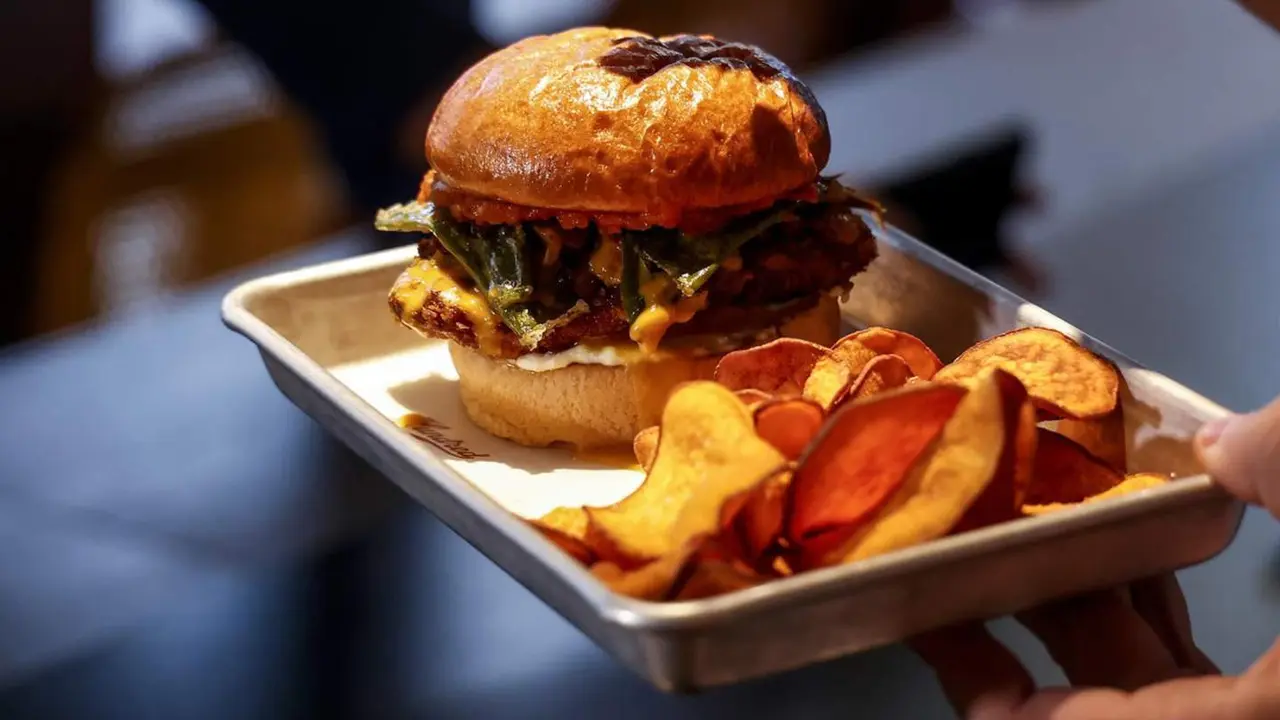  Archivo - Una persona sostiene una hamburguesa en una bandeja - Rober Solsona - Europa Press - Archivo 